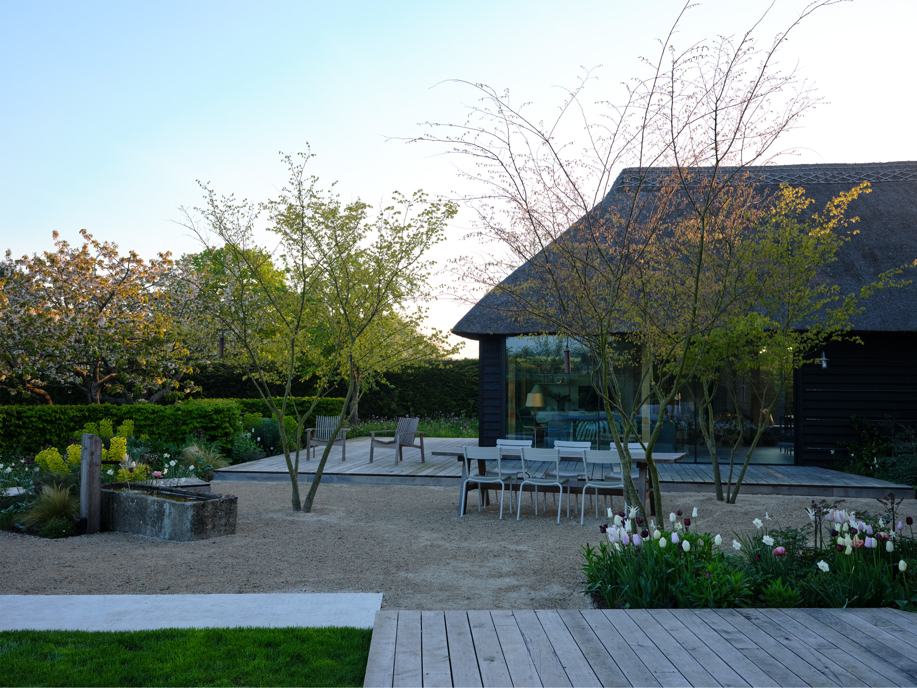 An outdoor dining space occupies a sunken courtyard